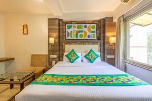 a bedroom with a bed and a table and a window at Treebo Aaram Orchard in Ahmedabad