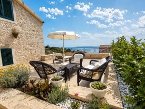 a patio with a table and chairs and an umbrella at Steinhaus Villa Ane in Tučepi