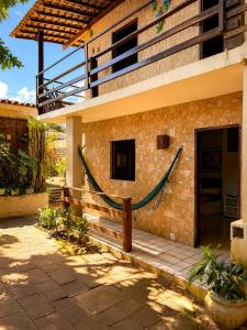 a house with a hammock on the side of it at Hotel Pousada Casuarinas in Recife
