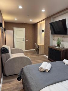 a hotel room with two beds and a flat screen tv at Sauna Dharma Stay Self check in in Telšiai