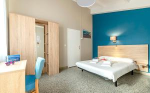 a bedroom with a bed with a blue wall at Azureva Club Ile d'Oleron in Grand-Village-Plage