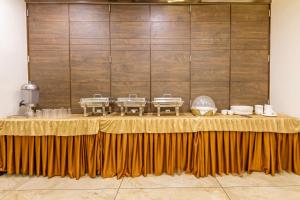 a table in a room with a yellow table cloth at Treebo Aaram Orchard in Ahmedabad
