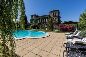 a patio with chairs and a swimming pool in front of a building at La tour du guet in Arouille