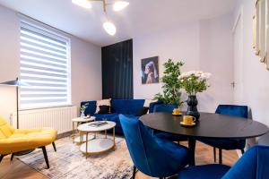 a living room with a table and blue chairs at Central Sheffield Stay, Work Trips, Contractors & City Breaks in Sheffield +13 photos