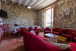 a restaurant with red chairs and a stone wall at La tour du guet in Arouille