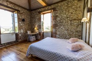 a bedroom with a bed and a stone wall at La tour du guet in Arouille +38 photos