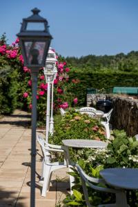 a street light next to tables and chairs with pink flowers at La tour du guet in Arouille