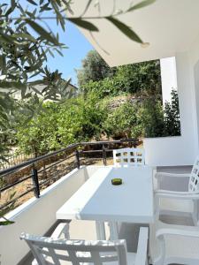 a white table and chairs on the balcony of a house at Roberts Villa in Dhërmi