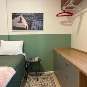 a bedroom with a bed and a small table with a small table at QUARTO INTEIRO com banheiro exclusivo Coração de Florianópolis in Florianópolis