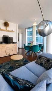 a living room with a blue couch and a table at Hub Retreat in Milton Keynes