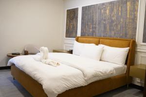a bedroom with a bed with a stuffed animal on it at Luxvill Hotel in Islamabad