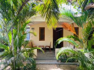 a house with palm trees in front of it at Super Bistro in Pottuvil