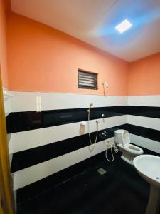 a bathroom with two toilets and orange and black stripes at Super Bistro in Pottuvil