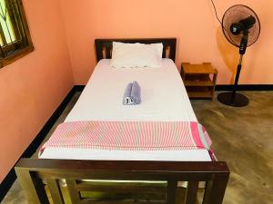 a bed with a pillow and a shoe on it at Super Bistro in Pottuvil