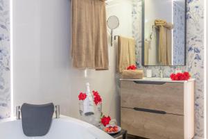 a bathroom with a tub and a sink and a mirror at Casa Parque Benavente Conil in Conil de la Frontera +16 photos