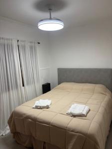 ein Schlafzimmer mit einem großen Bett, auf dem zwei Handtücher liegen in der Unterkunft Catarinas in Chivilcoy