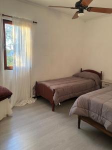 ein Schlafzimmer mit zwei Betten und einem Fenster in der Unterkunft Catarinas in Chivilcoy