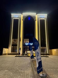 a building with a flag in front of it at night at إليت الجامعة -Elite Served Apartments - Hafar Al-Batin in Hafr Al-Batin