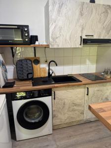 a kitchen with a washing machine and a microwave at AZURÉA Marina ! in Gourbeyre