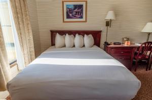 a bedroom with a large white bed and a desk at The Guv'nor Inn & Pub in St. John's