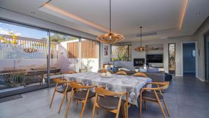 a dining room with a table and chairs and a couch at Pure Emotions Beach House in Knysna