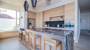 a kitchen with a large counter with stools around it at Pure Emotions Beach House in Knysna