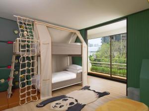 a kids room with a bunk bed and a window at Mövenpick BDMS Wellness Resort Bangkok in Bangkok
