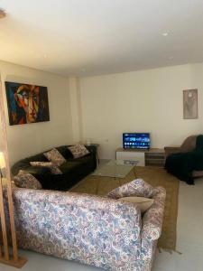 a living room with a couch and a tv at Rabat Easy Access ll in Rabat +1 photo