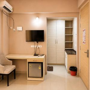 a room with a desk with a tv on the wall at Vrindavan Viharini Kunj in Chhatikara