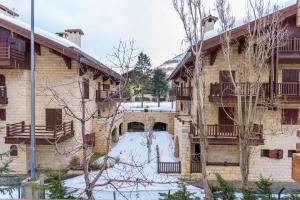 an apartment building with snow in the yard at Maison Montagne Mzaar in Kfardebian