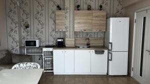 a kitchen with white cabinets and a refrigerator at Briz in Varna City