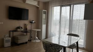 a living room with a glass table and a television at Briz in Varna City