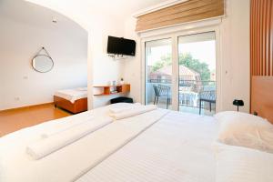 a large white bed in a room with a balcony at Lux Ariana in Donji Štoj +28 photos