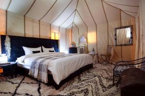 a bedroom with a large bed in a tent at Camping nature in Jeradat