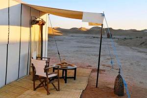 a table and a chair under a tent in the desert at Camping nature in Jeradat