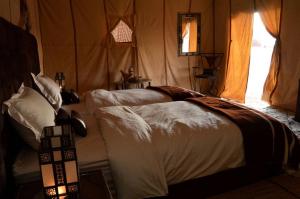 a bedroom with two beds in a tent at Camping nature in Jeradat