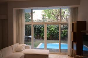 a living room with a view of a pool through a window at Luxury 4BR New Cairo Villa with Pool & Stylish Living - FAMILY ONLY in Cairo