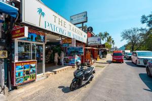 a scooter parked on the side of a street with shops at The Taksim Bangla Beach Hotel in Patong Beach