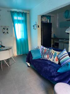 a living room with a blue couch and a kitchen at Maison de pêcheurs les petits quinquins in Étaples
