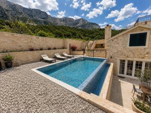 a swimming pool in the backyard of a house at Steinhaus Villa Ane in Tučepi