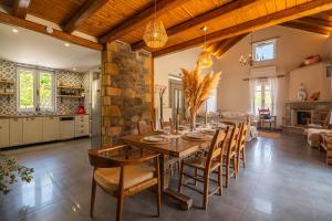 a kitchen and dining room with a wooden table and chairs at Villa 4 DESTINA in Élos