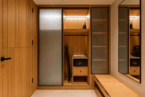 a walk in closet with wooden cabinets and a glass door at Radisson Hotel Nathdwara in Nāthdwāra +105 photos