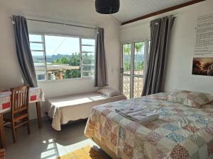 a bedroom with a bed and a window and a chair at Pousada Dona Terezinha in Formiga +107 photos