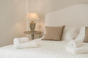 a bedroom with a white bed with towels on it at Villa Telli in Garda