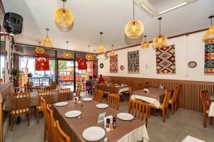 a restaurant with wooden tables and chairs and lights at The Taksim Bangla Beach Hotel in Patong Beach