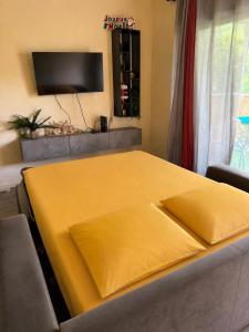 a bed with a yellow sheet on top of it at AZURÉA Marina ! in Gourbeyre