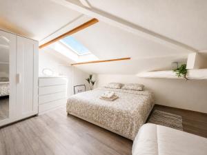 a white bedroom with two beds and a skylight at " L'Oratoire Mansardé " Linge fourni - Wifi - TV in Lagardelle-sur-Lèze