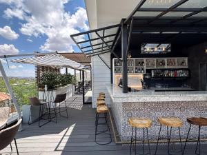 a bar on the roof of a building with stools at The Weinberg Windhoek in Windhoek