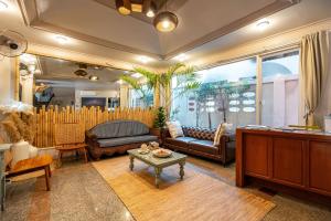 a living room with a couch and a table at The Taksim Bangla Beach Hotel in Patong Beach