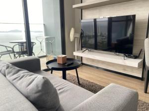 a living room with a couch and a table at Stunning Sea View Condo -Next To Beach in Pattaya South